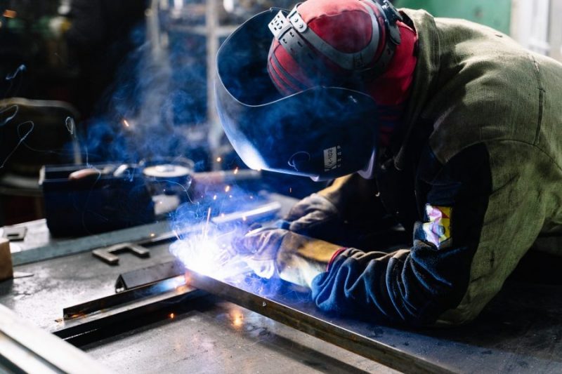 man working on laser cutting machine for manufacturing project