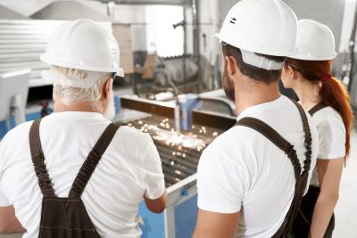 engineers observing laser cutting sheet metal 