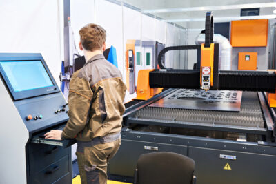 engineer working on cutting metal with laser cutting machine