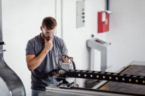 laser cutting aluminum, engineer setting up laser cutter