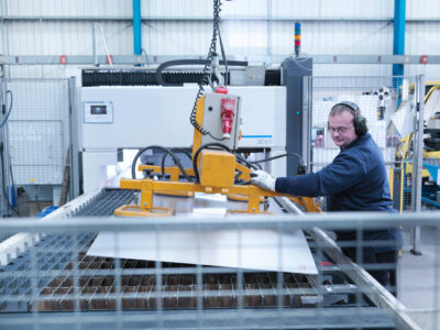 engineer working on sheet metal into laser cutter 